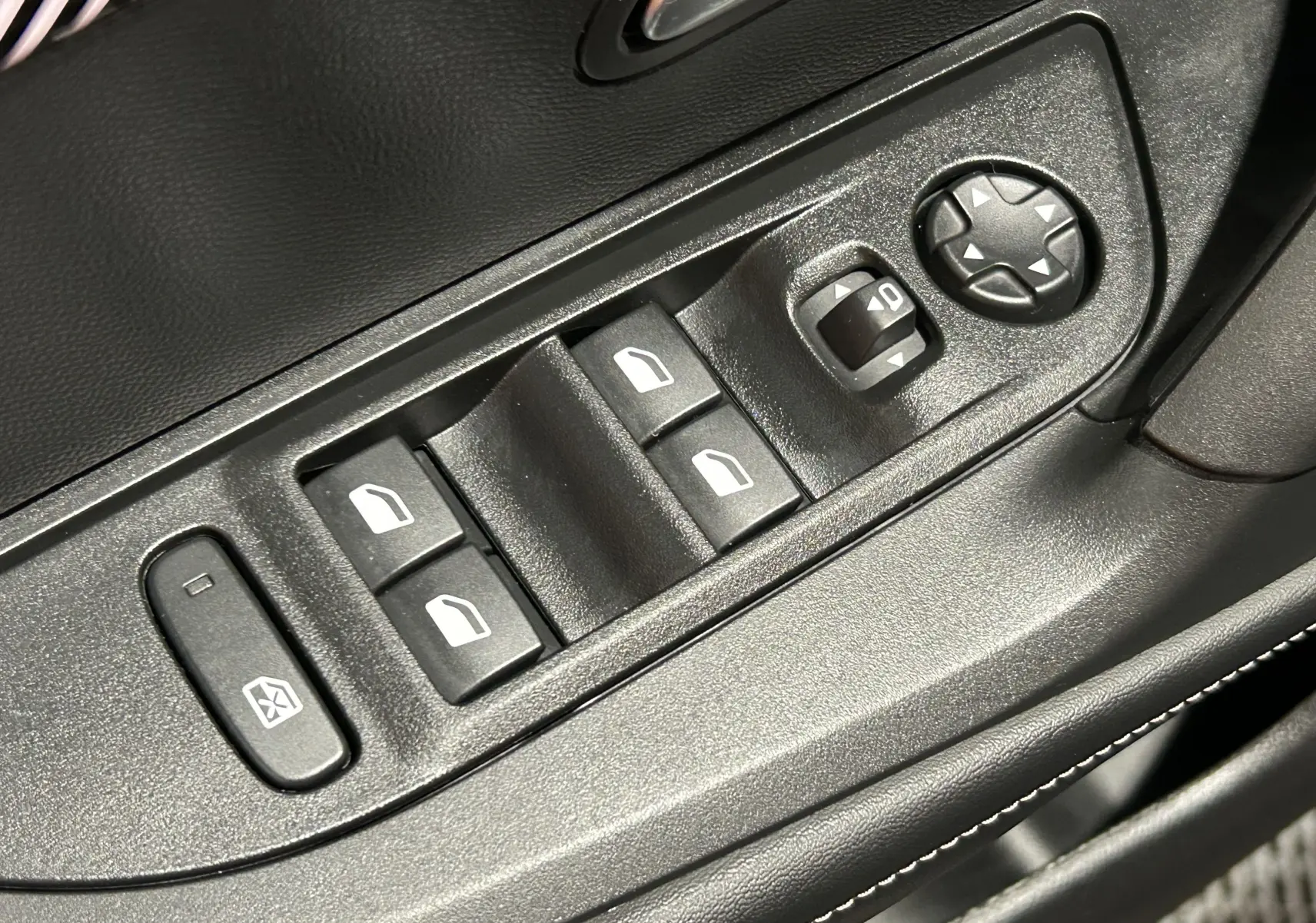 Gros plan sur les commandes de lève-vitres et réglage des rétroviseurs côté gauche intérieur du Peugeot 2008 bleu Obsession.