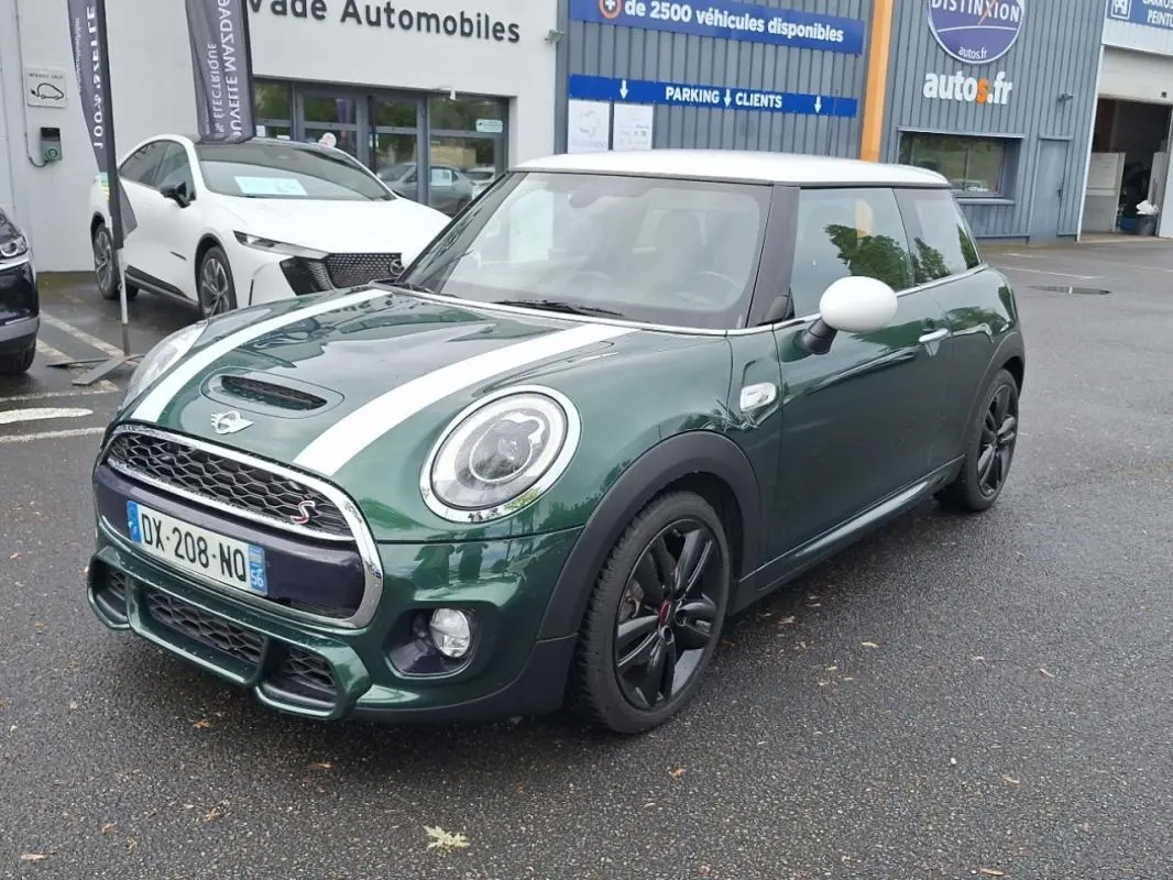 Vue 3/4 avant droite d'une MINI S John Cooper Works verte avec toit blanc et bandes blanches sur capot.