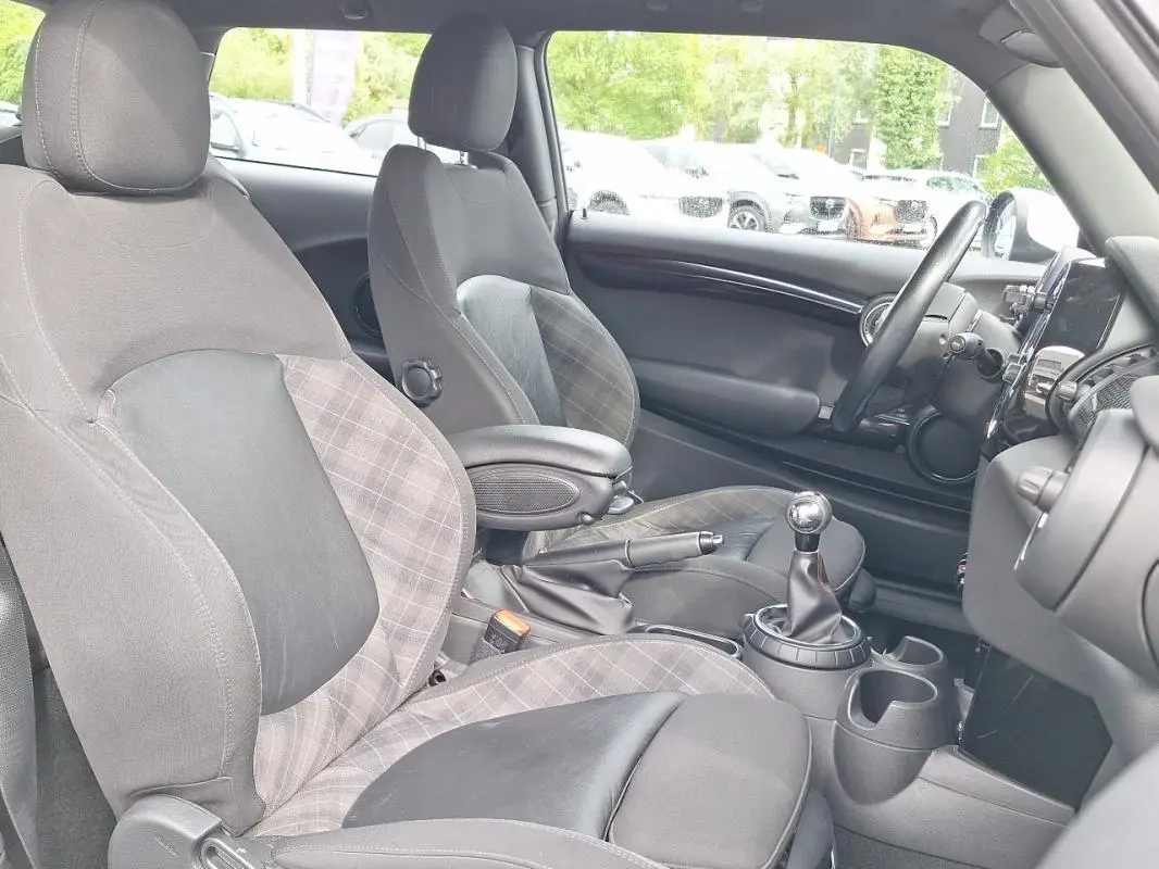 Vue intérieure côté conducteur de la MINI S John Work 2015, montrant les sièges en tissu à motif écossais et la boîte manuelle.