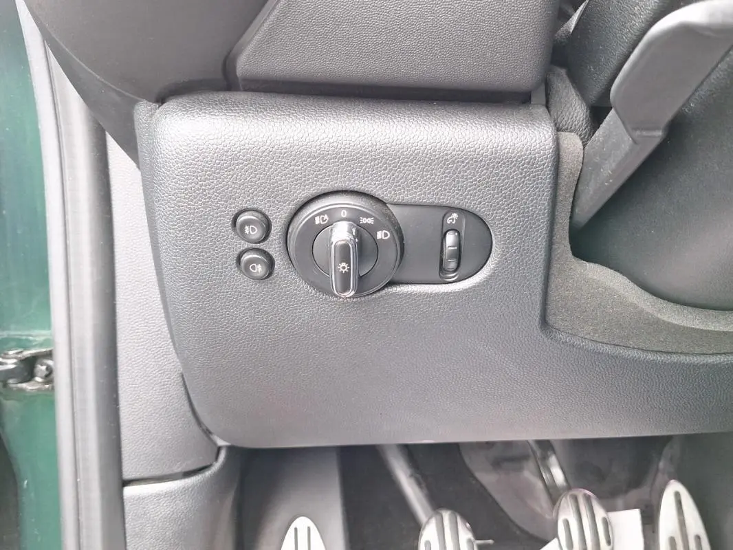 Détail du tableau de bord côté gauche avec commandes d’éclairage et pédalier en aluminium d’une MINI S John Cooper Works verte 2015.