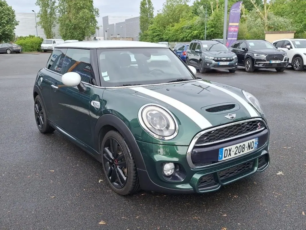 Vue 3/4 avant d'une MINI S finition John Cooper Works verte avec toit blanc et bandes blanches sur le capot.