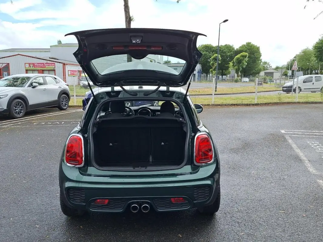 Vue arrière d'une MINI S finition John Cooper Works verte de 2015, coffre ouvert et double sortie d'échappement centrale visible.