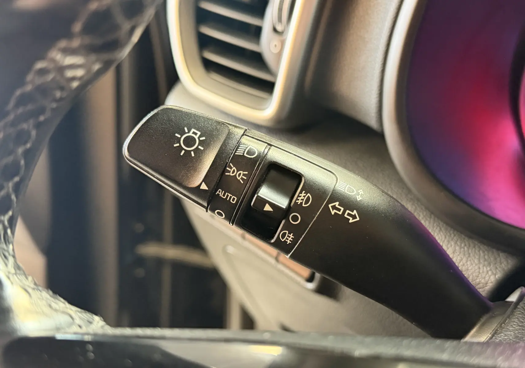 Gros plan sur la commande des feux et clignotants du KIA Sportage 2019, intérieur noir avec détails en plastique mat.