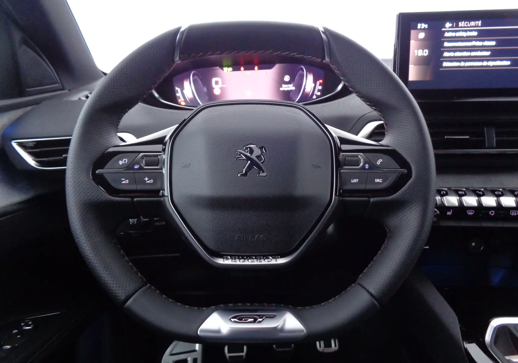 Vue rapprochée du volant cuir noir du Peugeot 5008 2023 GT avec tableau de bord numérique et écran central.