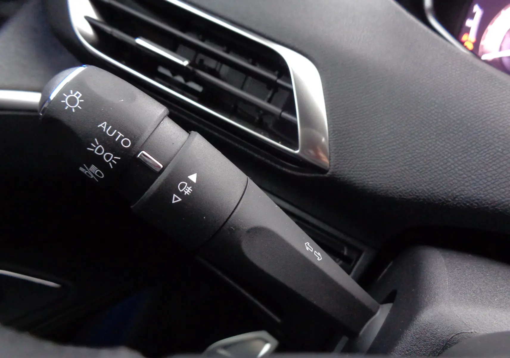 Gros plan sur la commande des phares et clignotants du Peugeot 5008 gris platinium métal, intérieur noir.