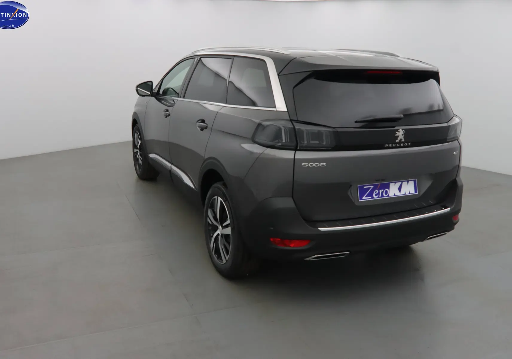 Peugeot 5008 gris platinium métal vue 3/4 arrière droit, feux arrière noirs et jantes alliage bicolores.
