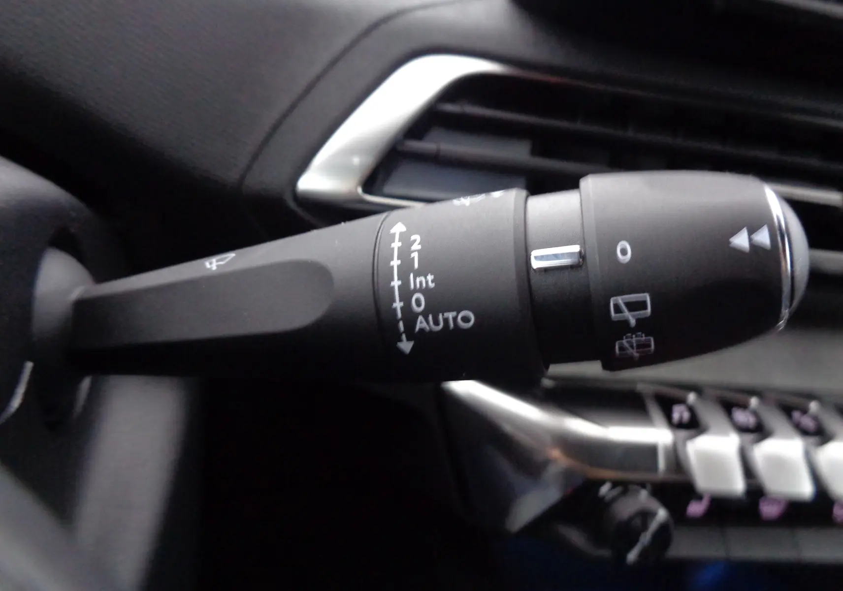 Gros plan sur la commande d’essuie-glace du Peugeot 5008 gris platinium, montrant les réglages automatiques et manuels.