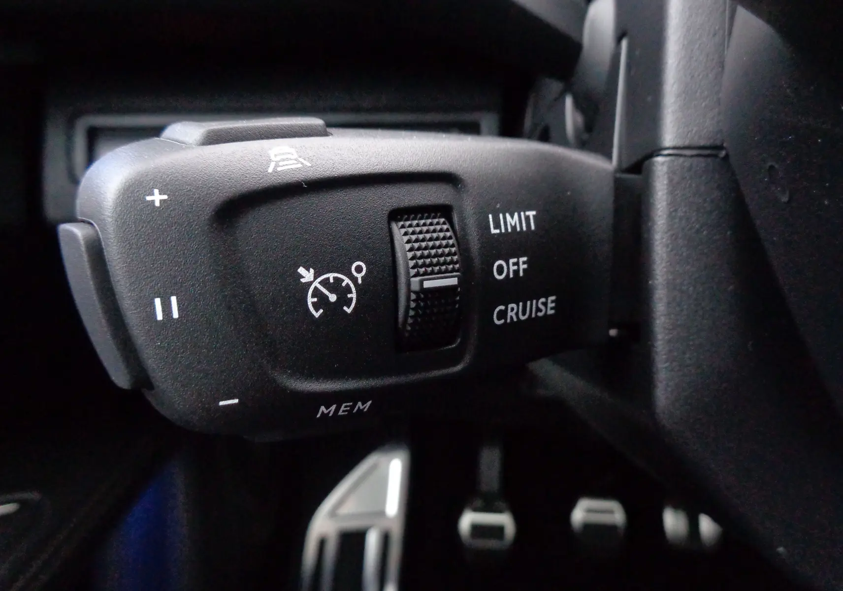 Gros plan sur la commande de régulateur de vitesse du Peugeot 5008 gris platinium, côté gauche du volant.