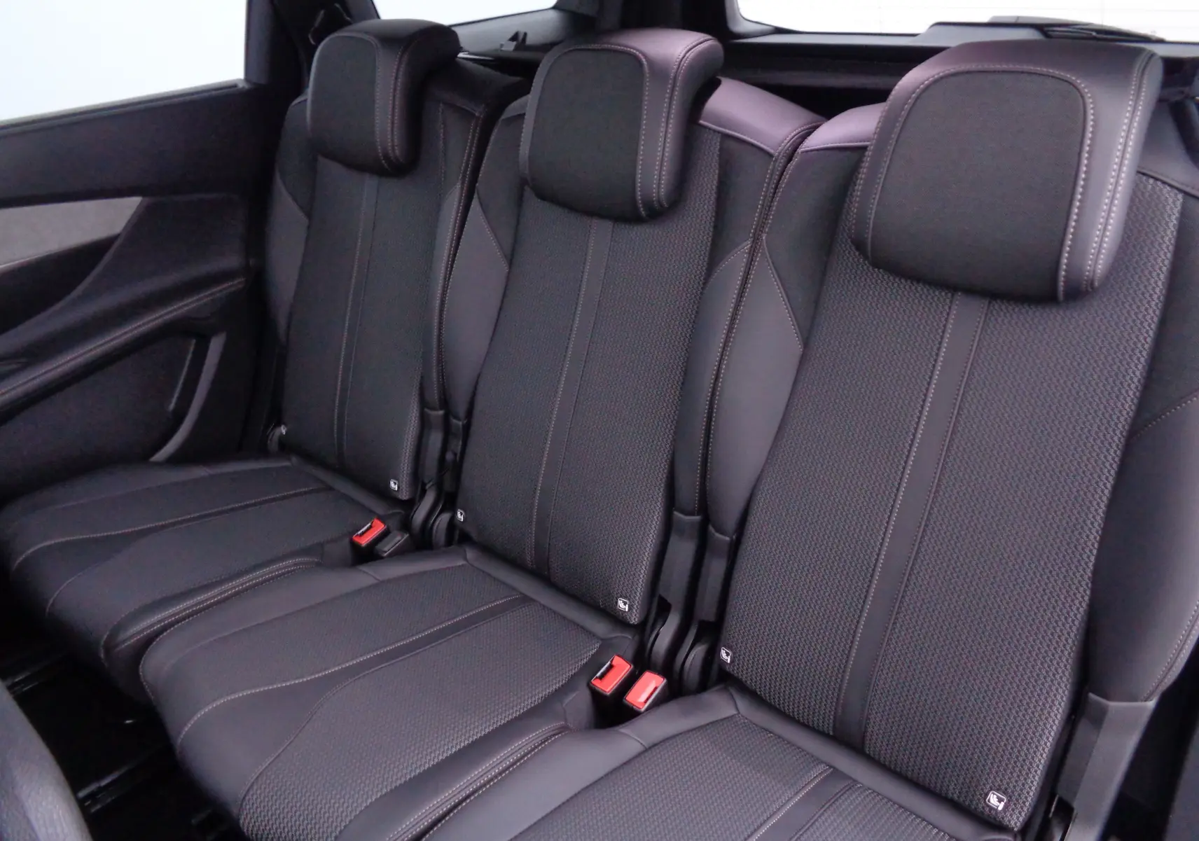 Vue rapprochée des sièges arrière noirs en cuir et tissu du Peugeot 5008 GT 2023, finition soignée et appuie-têtes intégrés.