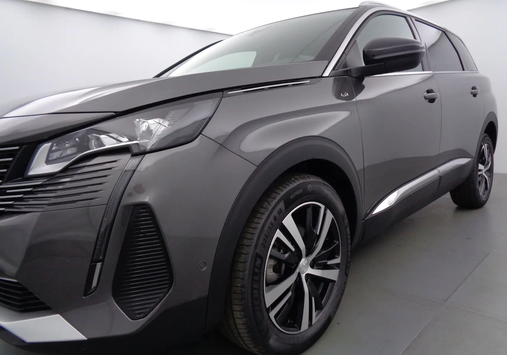 Vue 3/4 avant droit du Peugeot 5008 gris platinium métal avec jantes alliage et feux LED distinctifs.