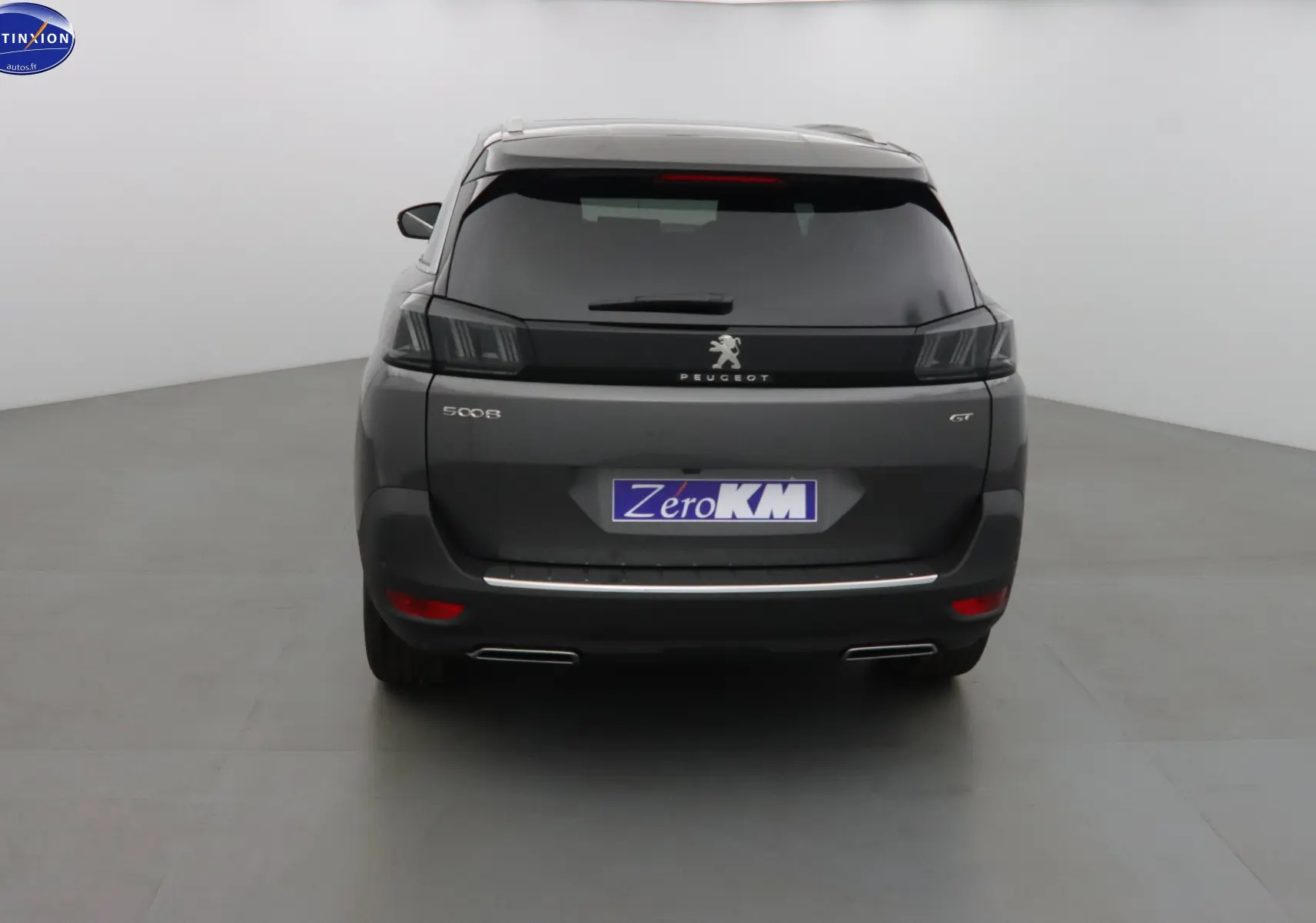 Vue arrière du Peugeot 5008 gris platinium métal 2023 avec feux LED et double sortie d'échappement chromée.