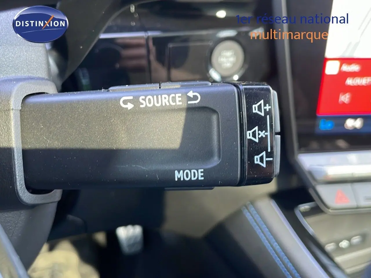 Gros plan sur la commande au volant du Renault Espace blanc nacré 2025, mettant en valeur les fonctions audio source et mode.