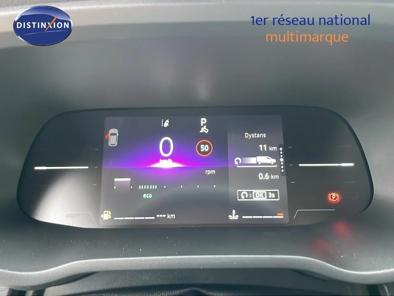 Tableau de bord numérique du Renault Trafic Fourgon blanc glacier 2025 affichant vitesse à 0 km/h et indicateurs de distance et parking.