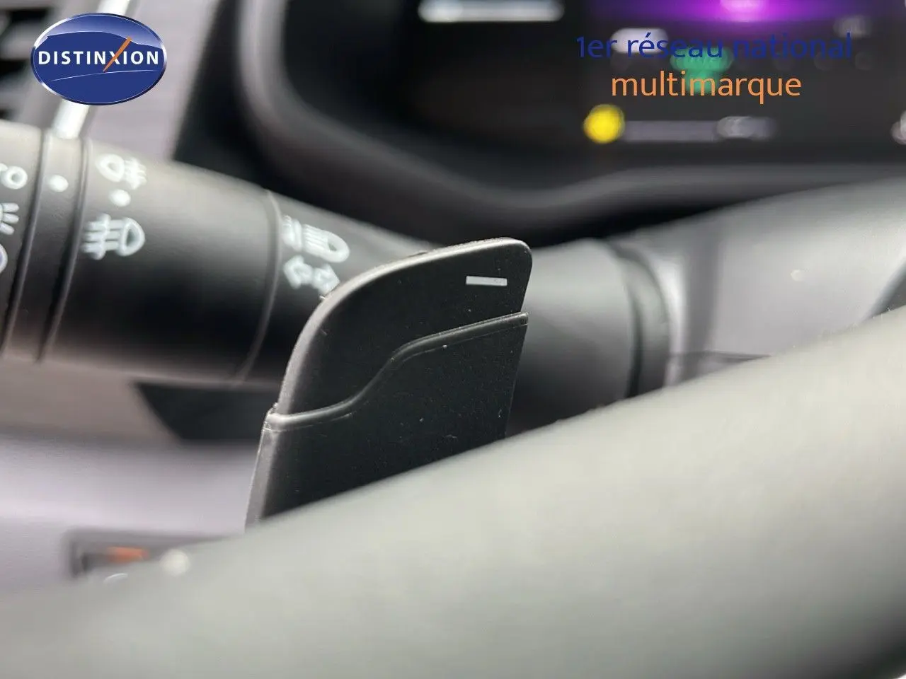 Gros plan sur la palette de changement de vitesse noire à droite du volant du Renault Trafic Fourgon blanc glacier.