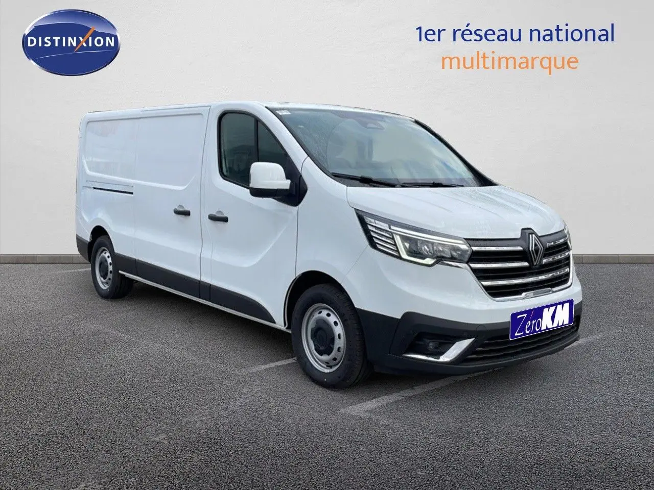 Renault Trafic Fourgon blanc glacier vu en 3/4 avant droit, avec calandre chromée et phares LED allumés.