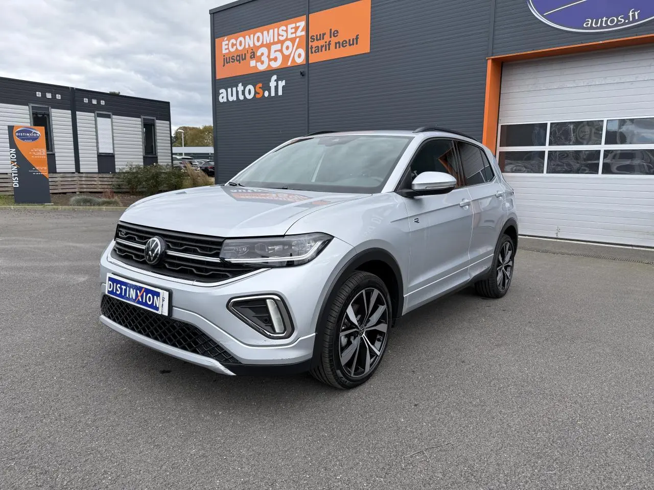 Volkswagen T-Cross gris cendre en 3/4 avant droit, avec jantes alliage 18 pouces et calandre R-Line visible.