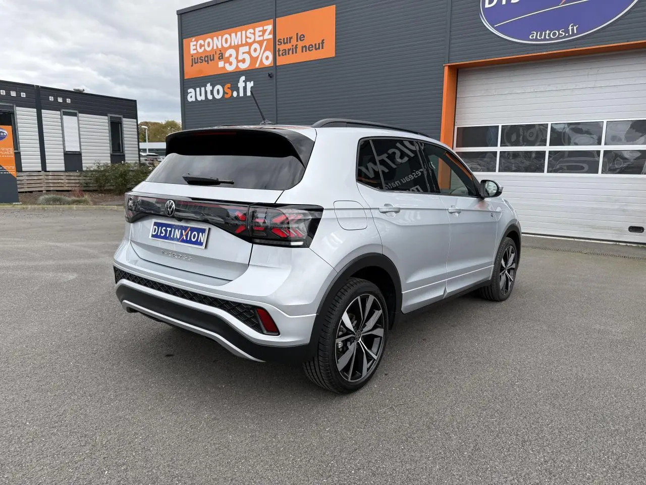 Vue 3/4 arrière droite d'un Volkswagen T-Cross gris cendre avec jantes alliage 18 pouces et vitres surteintées.