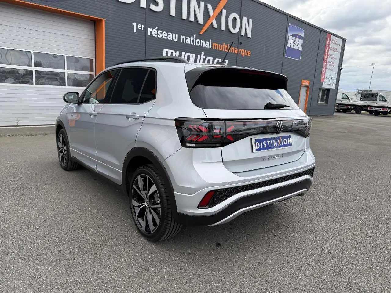 Vue 3/4 arrière droite d'un Volkswagen T-Cross gris cendre avec jantes alliage 18 pouces et vitres surteintées.