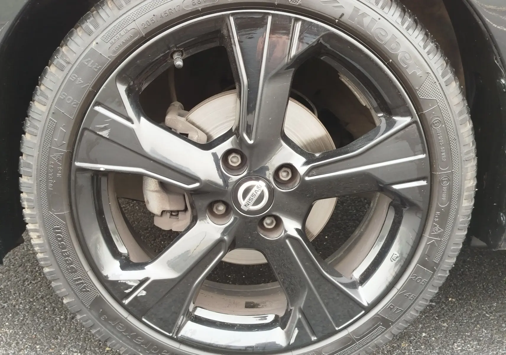 Gros plan sur la jante noire brillante de la Nissan Micra 2022, mettant en valeur le logo central et le pneu Kleber.