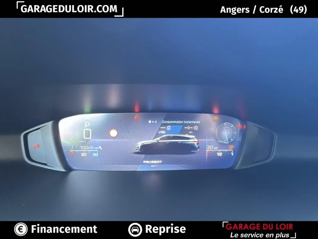 Affichage numérique du tableau de bord de la Peugeot 308 gris clair, montrant la consommation instantanée et la vitesse.