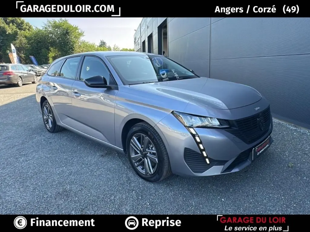 Peugeot 308 BlueHDi gris clair vue 3/4 avant droit, avec feux LED et calandre noire distinctive.