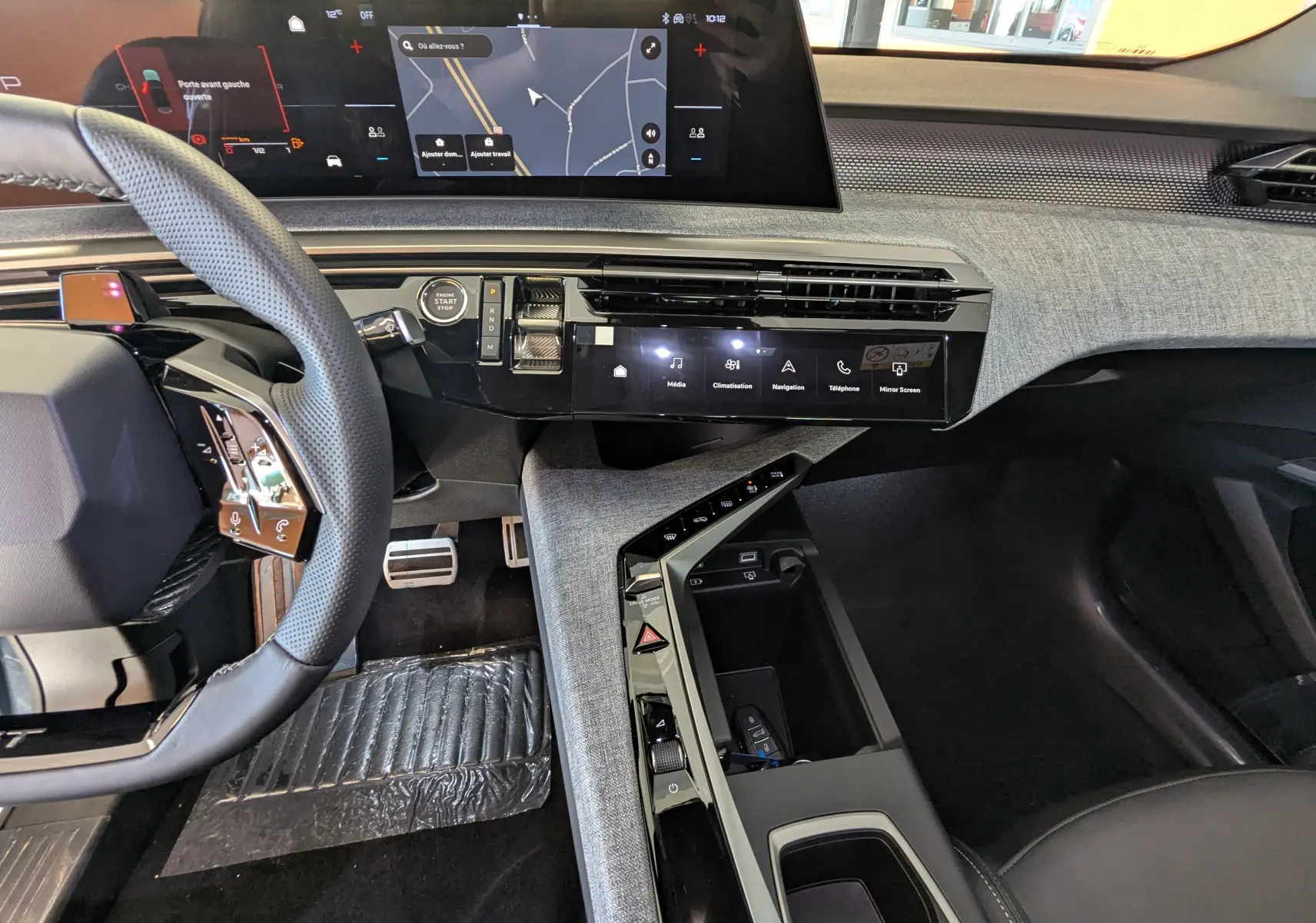 Vue intérieure côté conducteur du Peugeot 3008 Hybrid 2026, mettant en valeur le tableau de bord numérique et la console centrale moderne.