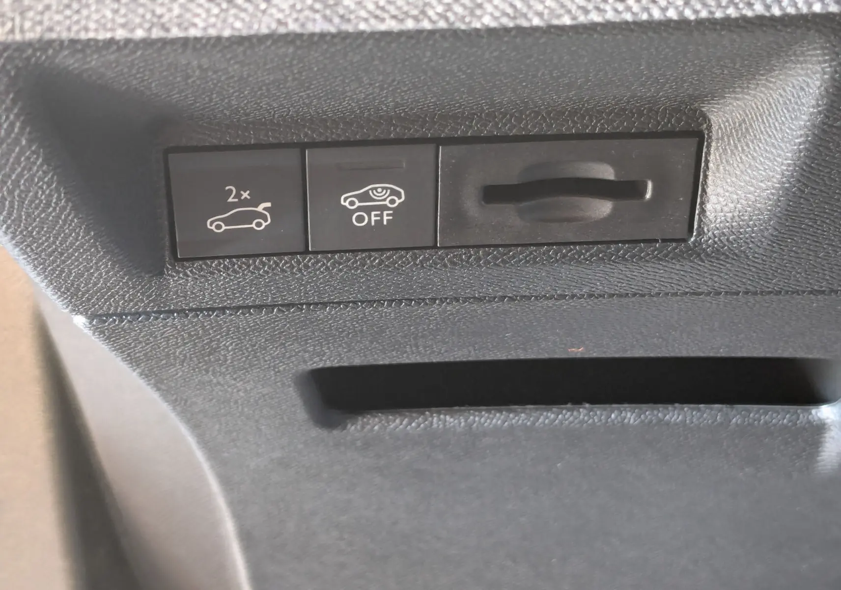 Gros plan sur les boutons de commande intérieurs noirs du Peugeot 3008 1.2 Hybrid, avec pictogrammes blancs.