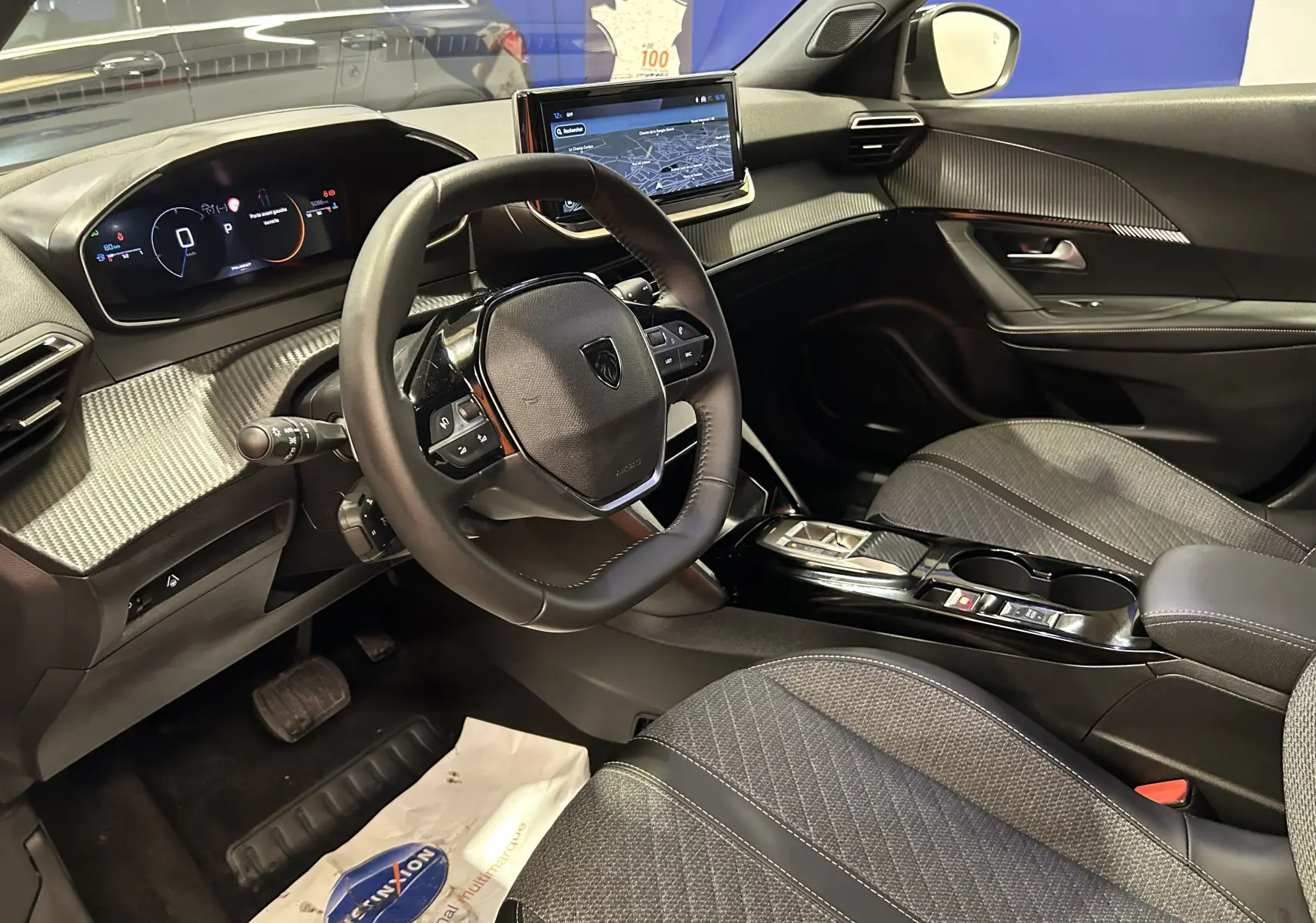 Vue intérieure côté conducteur du Peugeot 2008 gris Selenium avec tableau de bord numérique et écran tactile central.