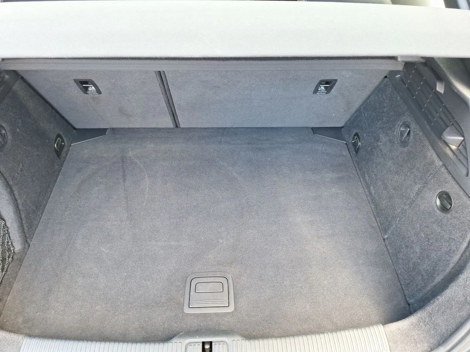 Coffre vide vu de dessus d'une Audi A3 gris 2017, avec revêtement intérieur en tissu sombre.