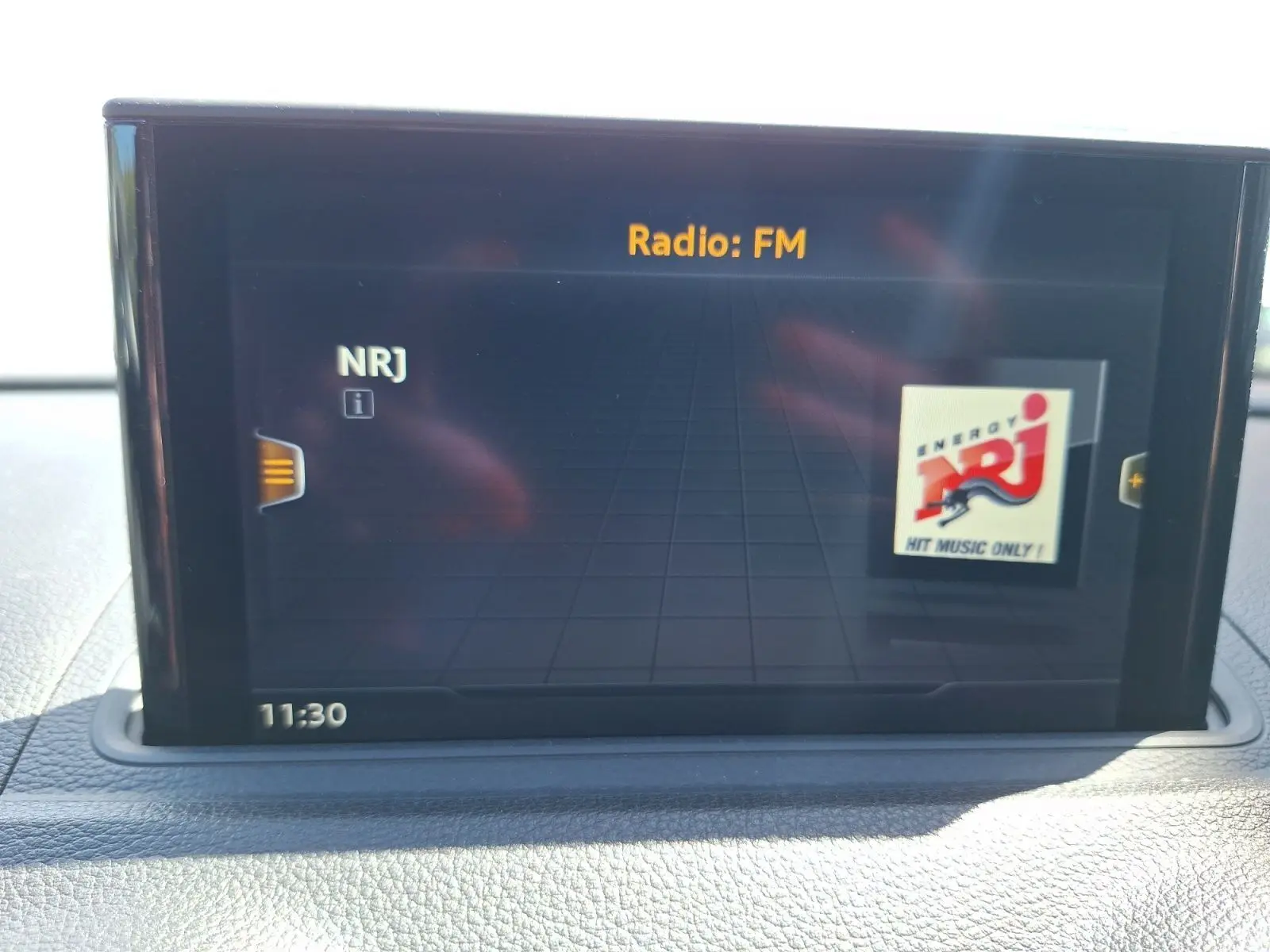 Écran central de l'Audi A3 2017 gris, affichant la radio FM NRJ avec interface numérique moderne.