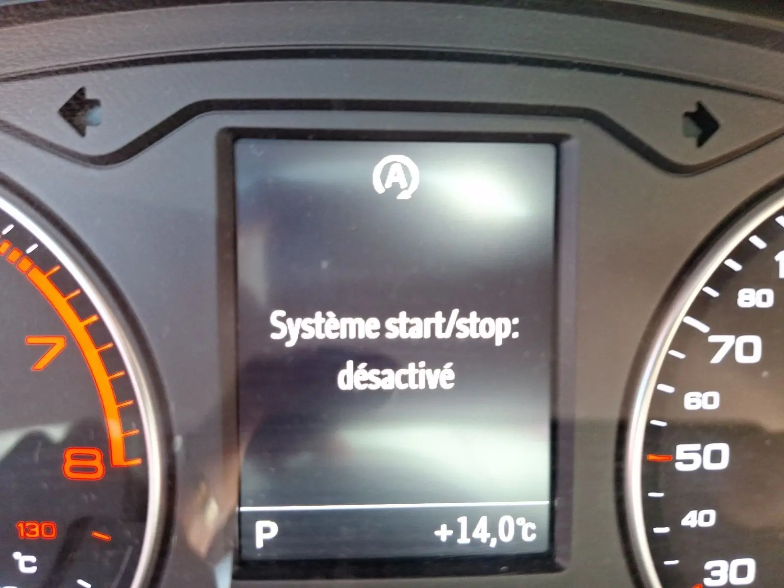 Gros plan sur l'écran du tableau de bord de l'Audi A3 gris, affichant "Système start/stop désactivé".