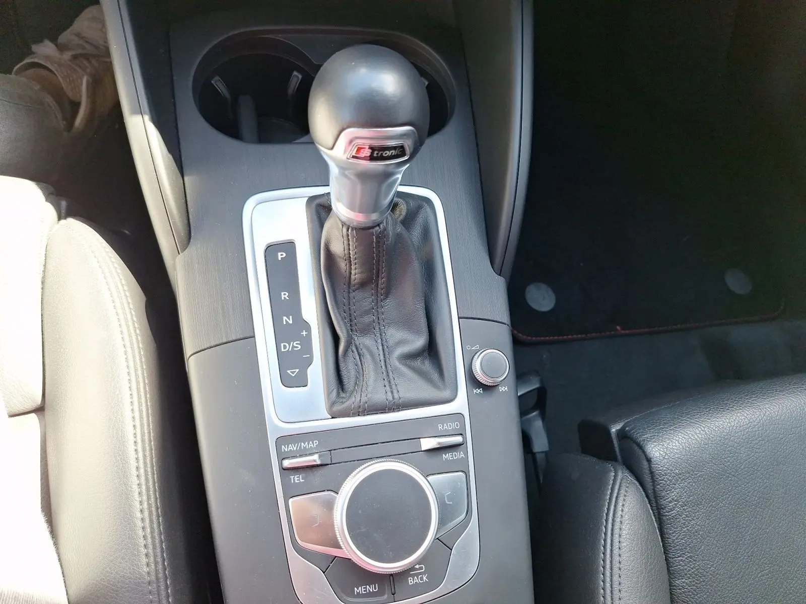 Gros plan sur la console centrale avec levier de vitesse S tronic et sellerie cuir noire de l'Audi A3 gris 2017.