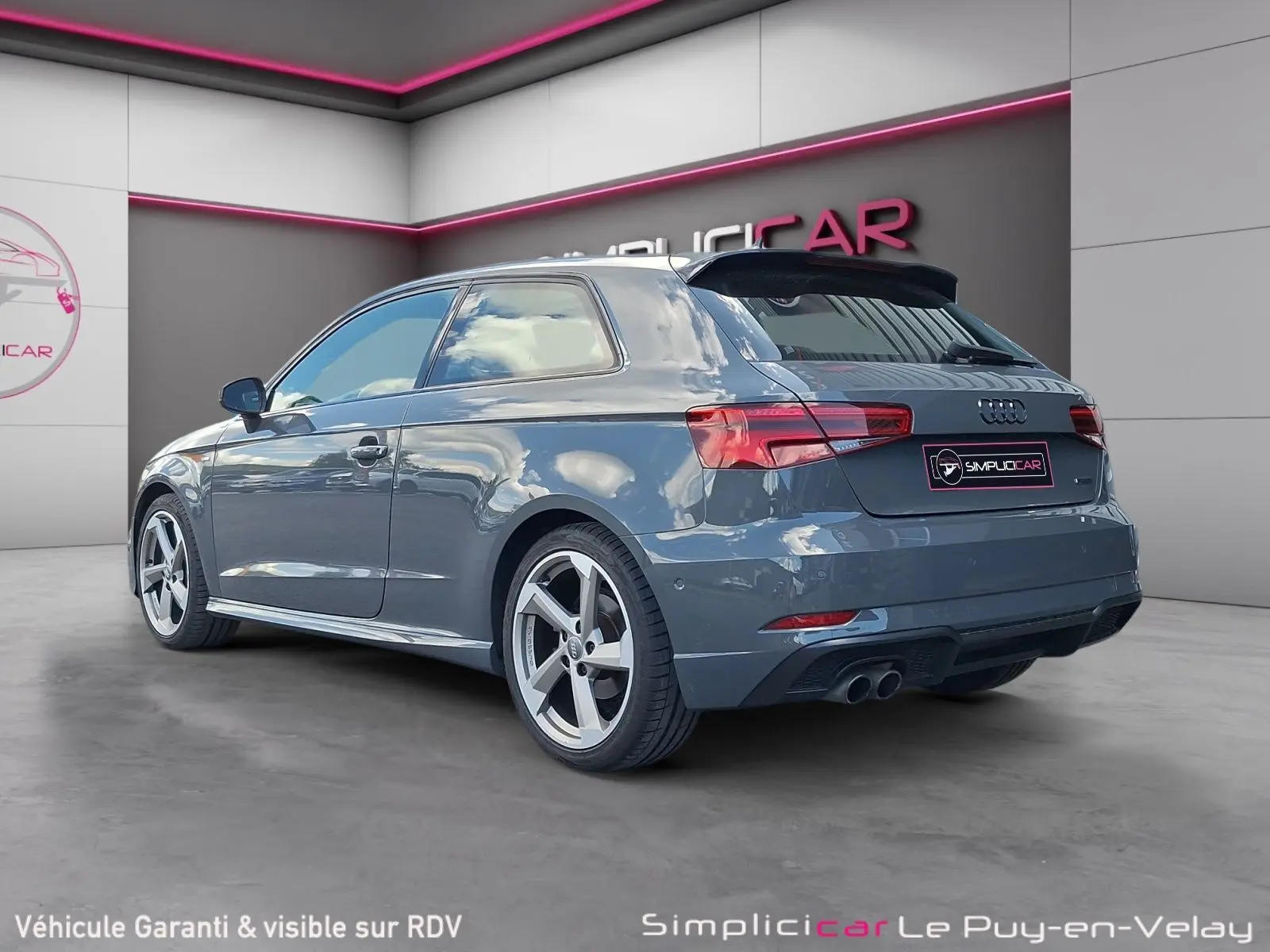 Audi A3 gris vue 3/4 arrière droit, avec jantes alliage 18 pouces et double sortie d’échappement.