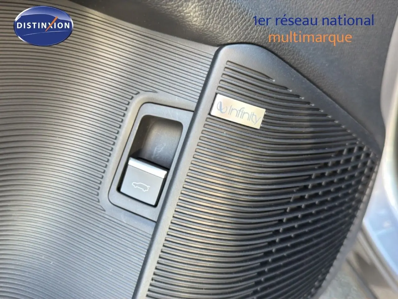 Détail intérieur montrant le bouton d'ouverture du coffre et le haut-parleur Infinity sur panneau noir du BYD SEAL U gris.