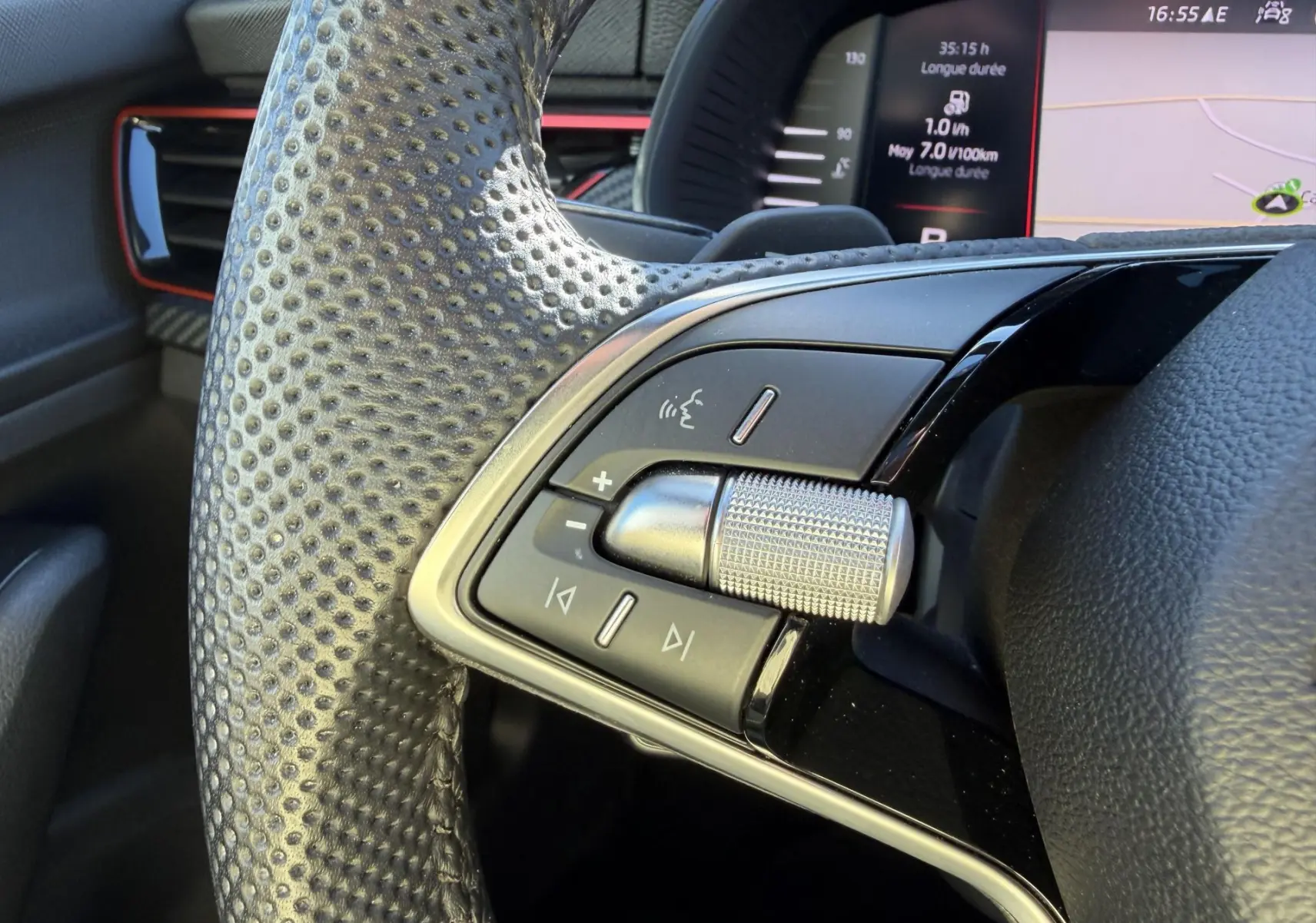 Gros plan sur le volant sport en cuir perforé côté gauche du Skoda Kamiq 2025 avec commandes multifonctions et molette argentée.