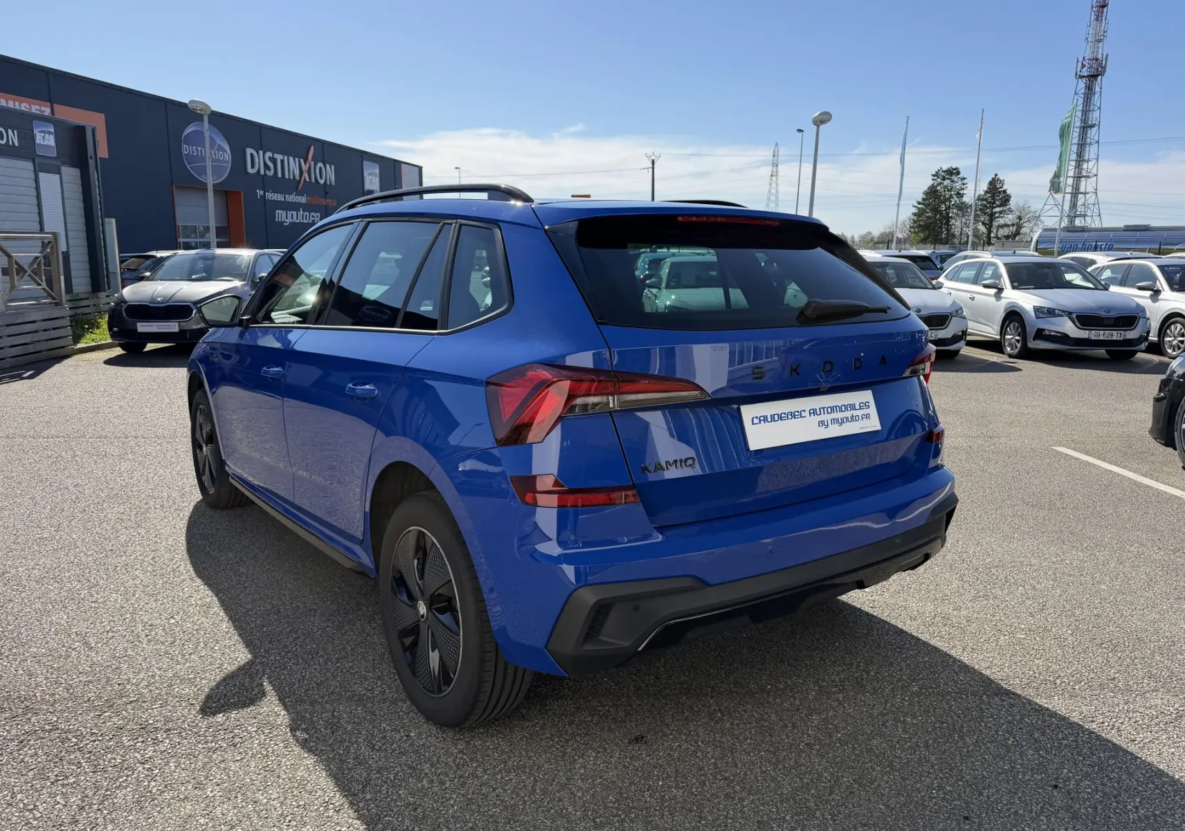 Vue 3/4 arrière droite d'un Skoda Kamiq bleu 2025 avec jantes alliage noires et feux arrière LED distinctifs.