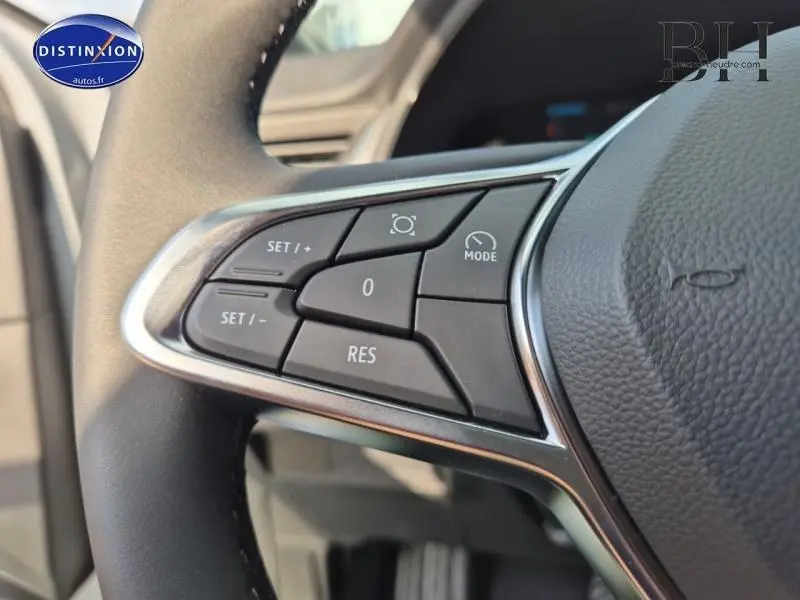 Gros plan sur les commandes multifonctions noires du volant cuir du Renault Captur gris Rafale 2025.