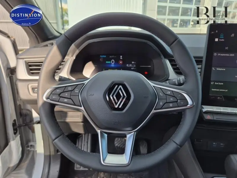 Vue frontale du volant noir multifonction du Renault Captur 2025 avec tableau de bord numérique et écran tactile.