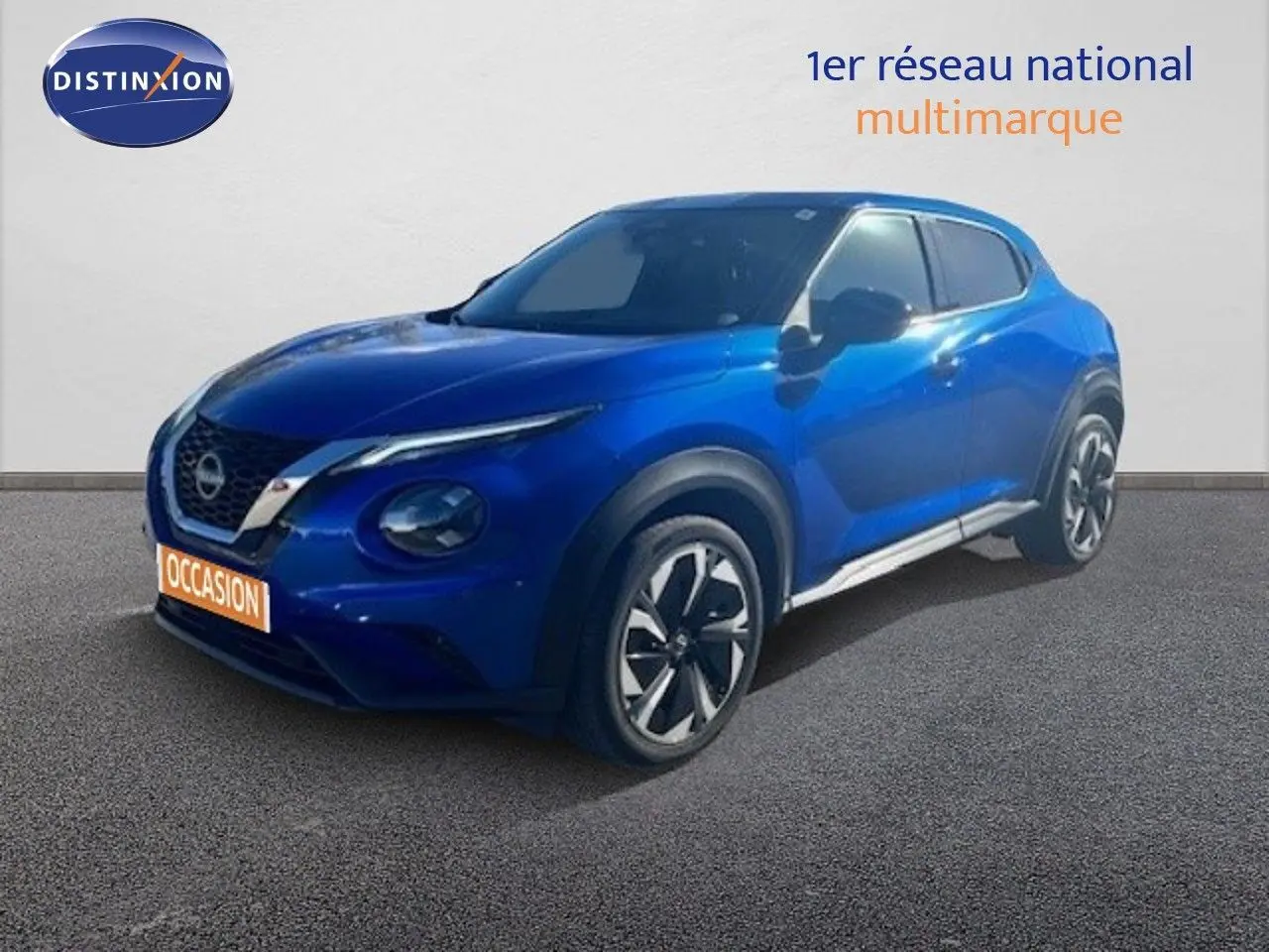 Nissan Juke bleu magnétique métal en 3/4 avant droit, avec jantes alliage et calandre distinctive V-Motion.