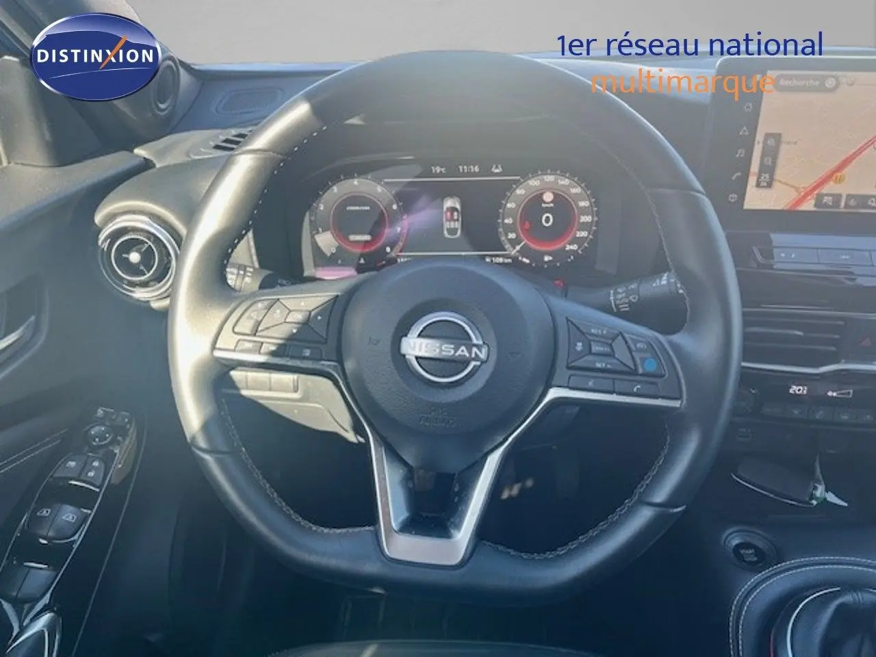 Vue rapprochée du volant cuir noir et tableau de bord numérique du Nissan Juke 2025, ambiance intérieure moderne.
