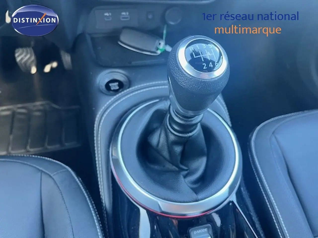 Le levier de vitesses manuel de la Nissan Juke 2025 en gros plan, entouré de cuir noir et surpiqûres grises.