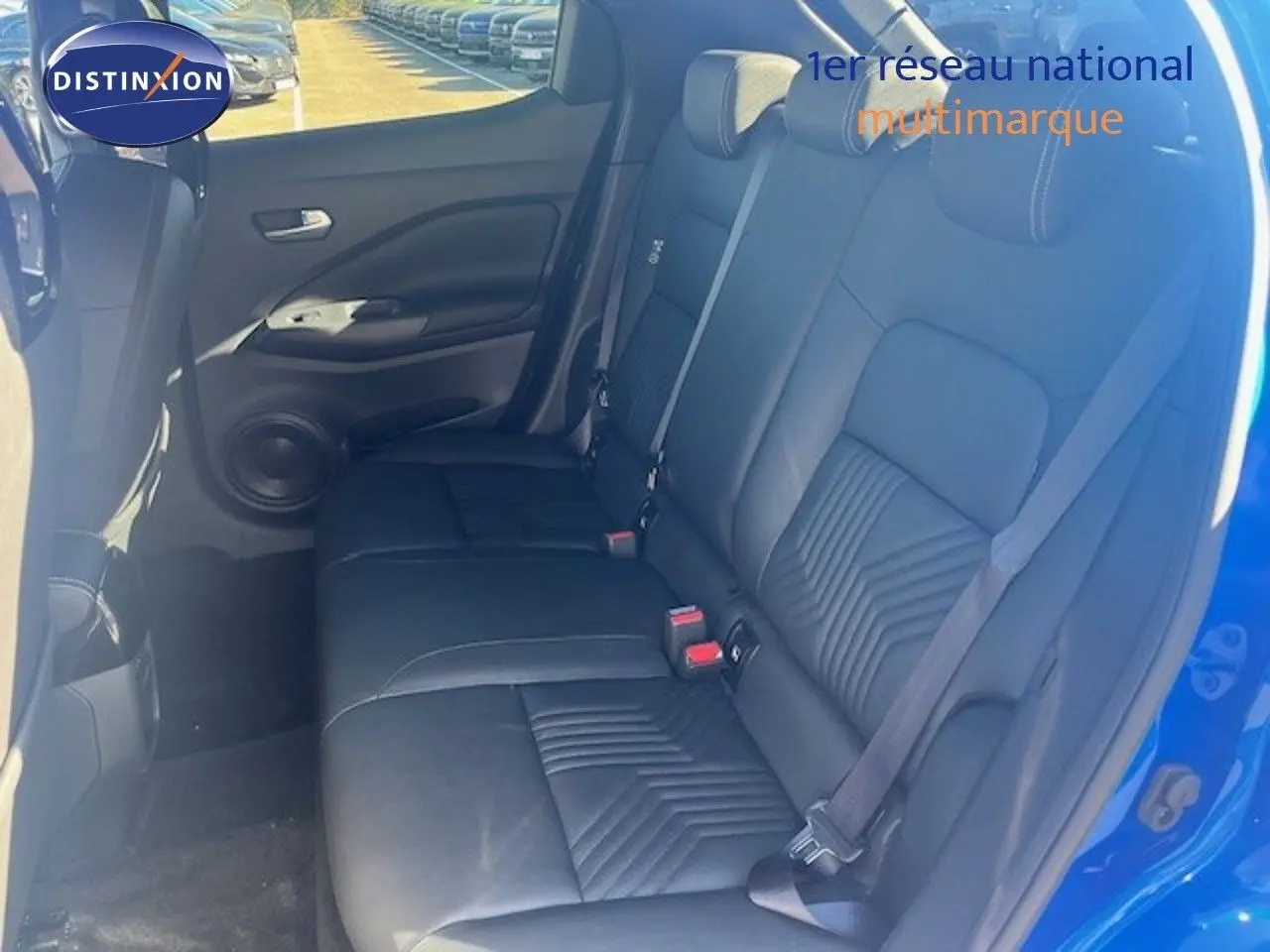 Vue intérieure arrière côté droit du Nissan Juke 2025 bleu magnétique, sièges en cuir noir avec ceinture de sécurité.