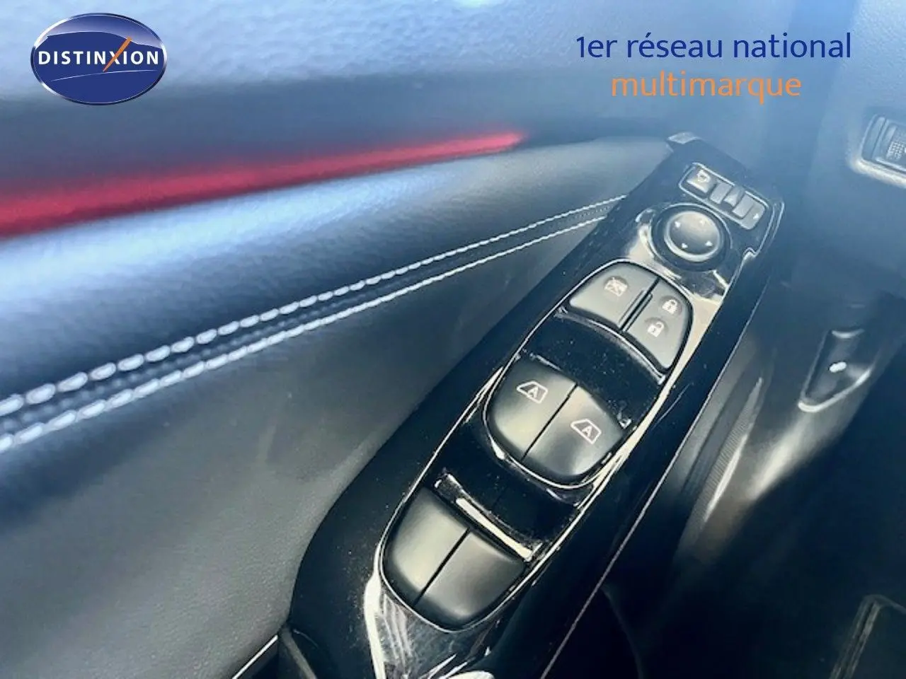 Gros plan sur les commandes de lève-vitres et verrouillage sur la portière intérieure noire du Nissan Juke 2025.