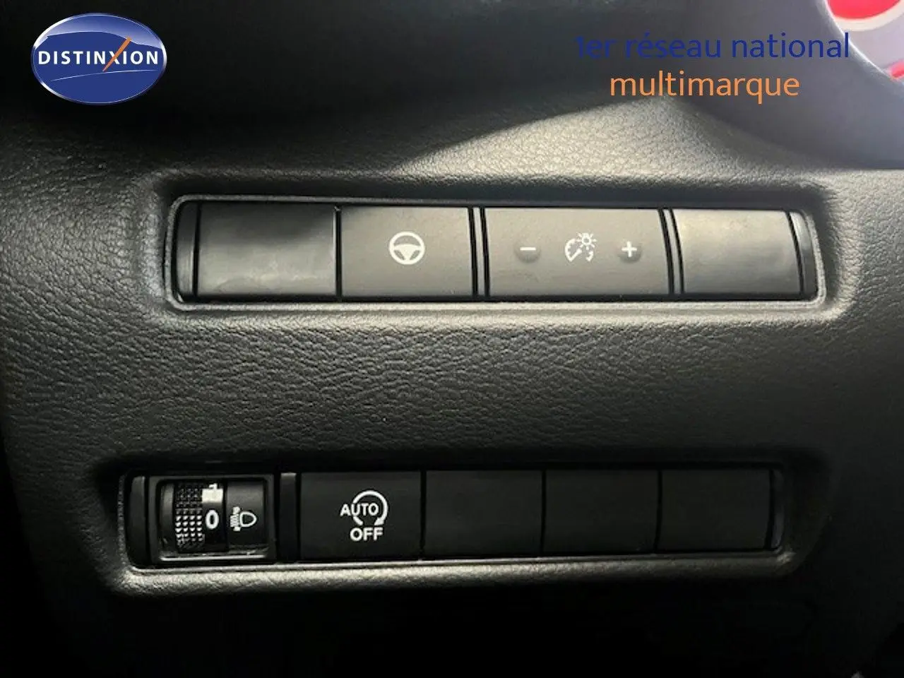 Gros plan sur les commandes de réglage d’éclairage et d’assistance au volant du Nissan Juke bleu magnétique.