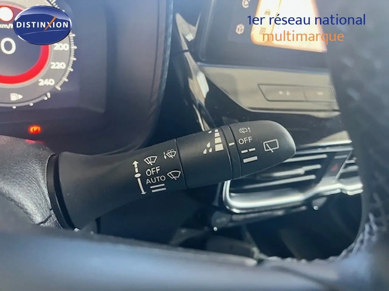 Gros plan sur la commande d'essuie-glace à gauche du volant dans un Nissan Juke bleu magnétique 2025.