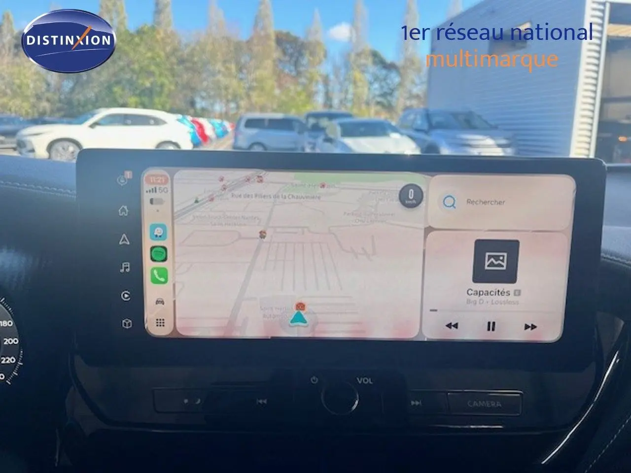 Vue avant du tableau de bord du Nissan Juke 2025 bleu magnétique, avec écran tactile affichant navigation et musique.