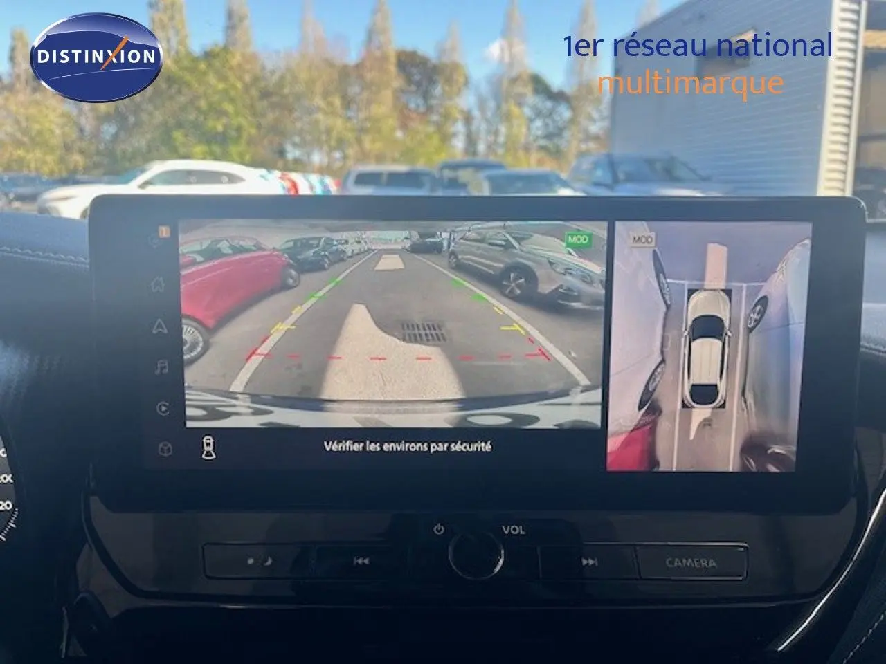 Vue intérieure sur l’écran multimédia affichant la caméra de recul et la vue 360° du Nissan Juke bleu magnétique métal.