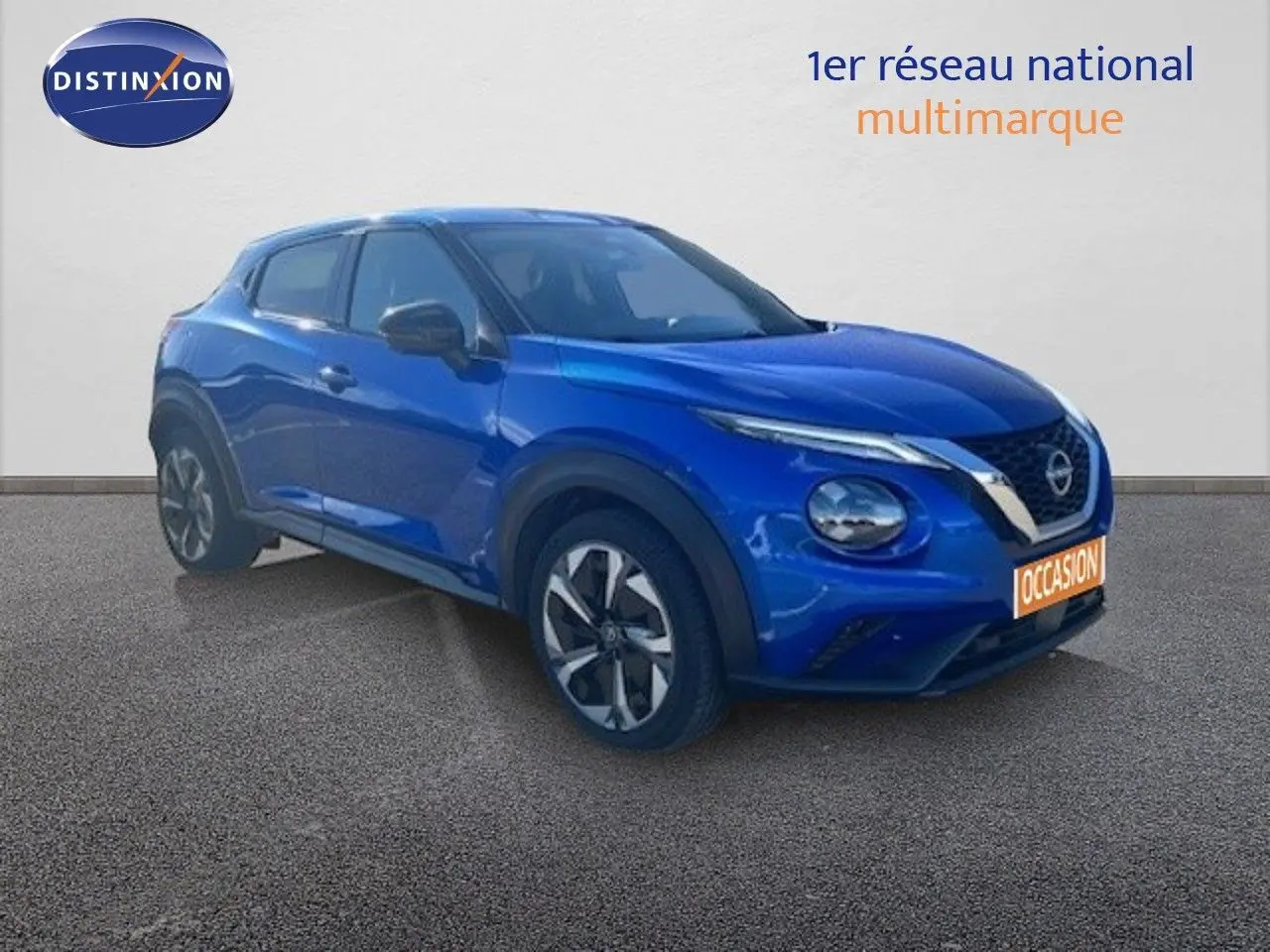 Nissan Juke bleu magnétique métal en 3/4 avant droit, avec jantes alliage et calandre distinctive V-Motion.
