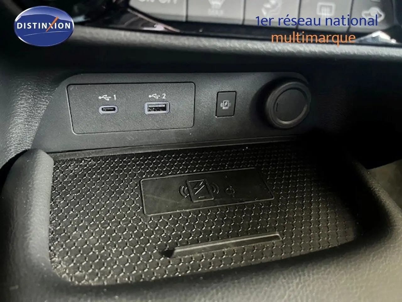 Gros plan sur la console centrale du Nissan Juke 2025, montrant les ports USB et la zone de charge sans fil.