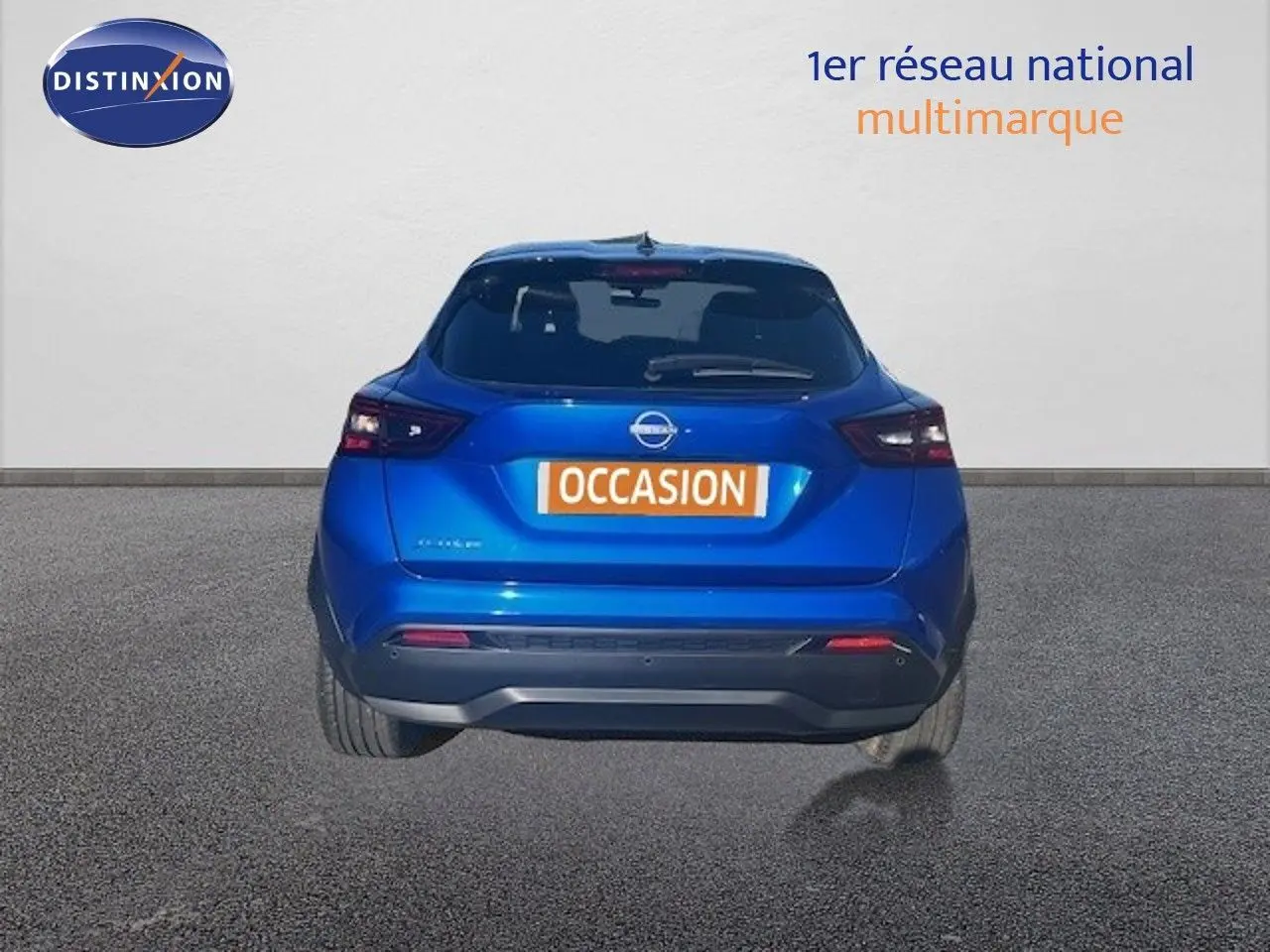 Vue arrière d'un Nissan Juke 2025 bleu magnétique métallisé avec feux arrière LED et plaque "OCCASION" visible.